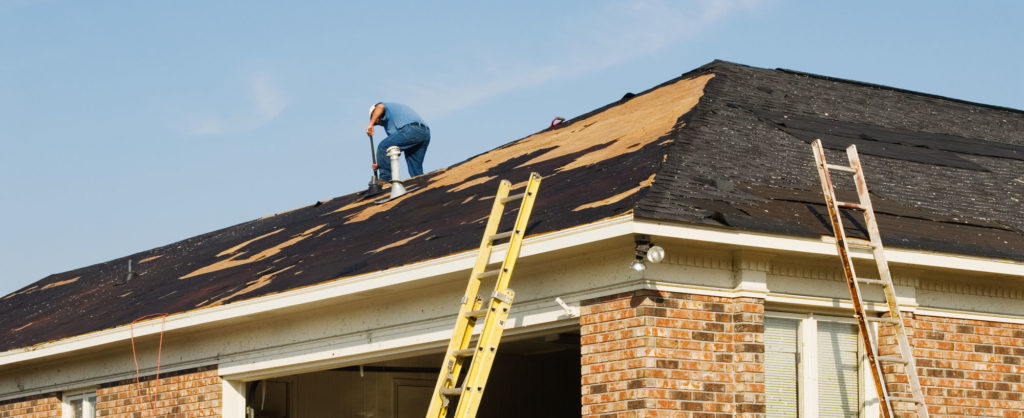 roofing contractor repairing the roof of a brick residential home